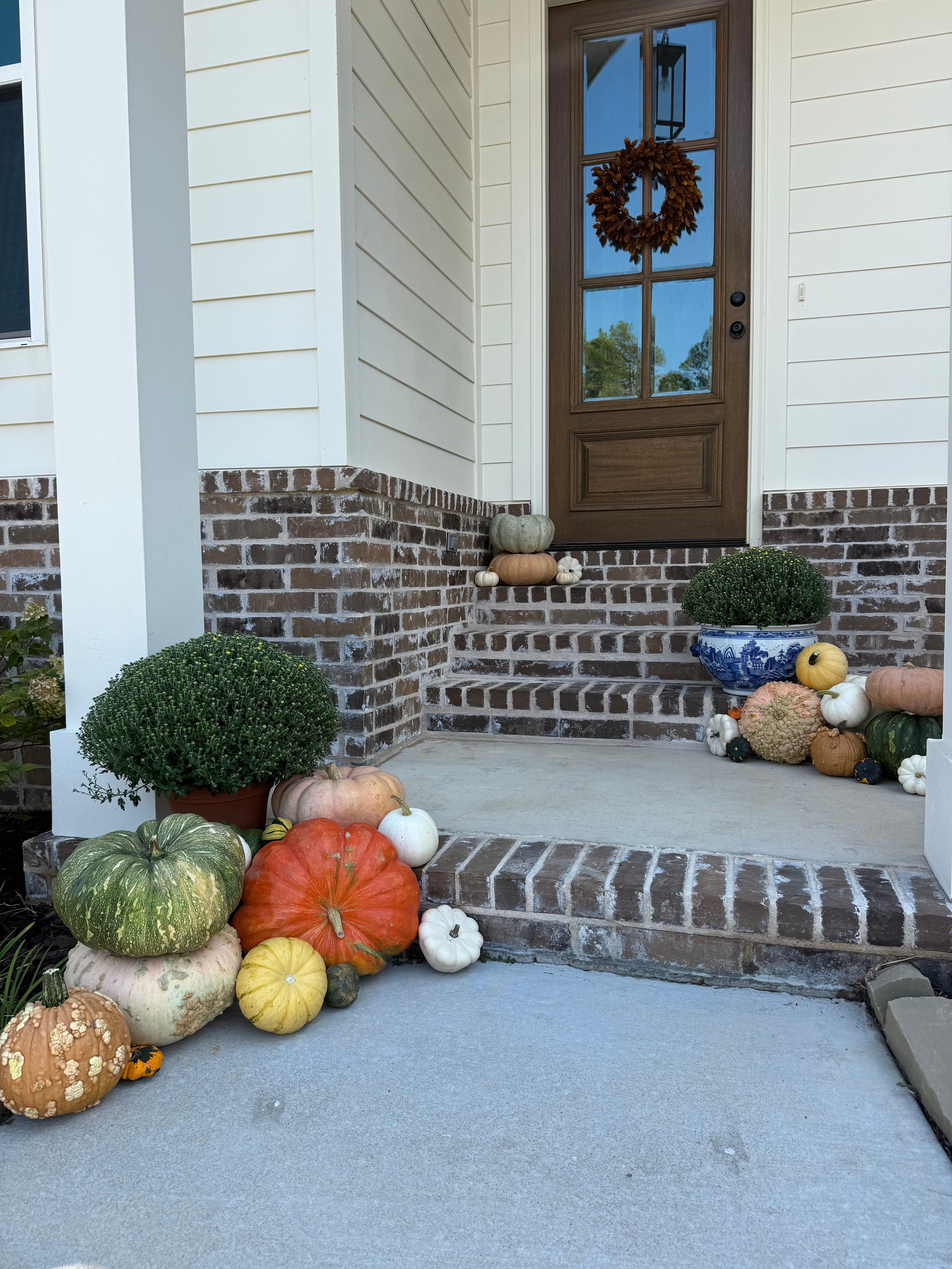 Harvest porch decor with mums and pumpkins